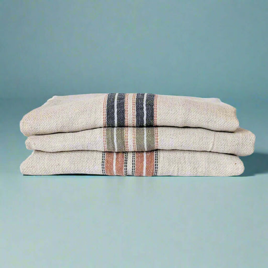 Terra red, navy blue and green hestia turkish towels folded and stacked on top of each other